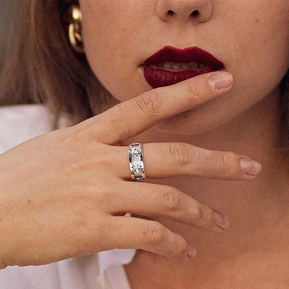 Frau trägt silbernen Herrenring mit Diamanten und rotierendem Zahnrad-Design.