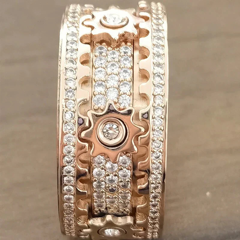 Roségoldener Ring mit Zahnrädern und Diamanten, luxuriöses Schmuckdesign, funkelndes Accessoire.