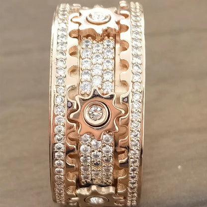 Roségoldener Ring mit Zahnrädern und Diamanten, luxuriöses Schmuckdesign, funkelndes Accessoire.