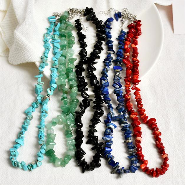 Mehrfarbige Edelstein-Halsketten aus Türkis, Aventurin, Onyx, Lapislazuli und Koralle auf weißem Hintergrund.