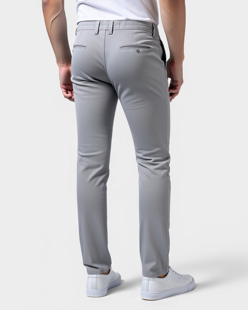Lysegrå chinos set bagfra på model med to paspolerede baglommer med knap og bælteløkker. 3