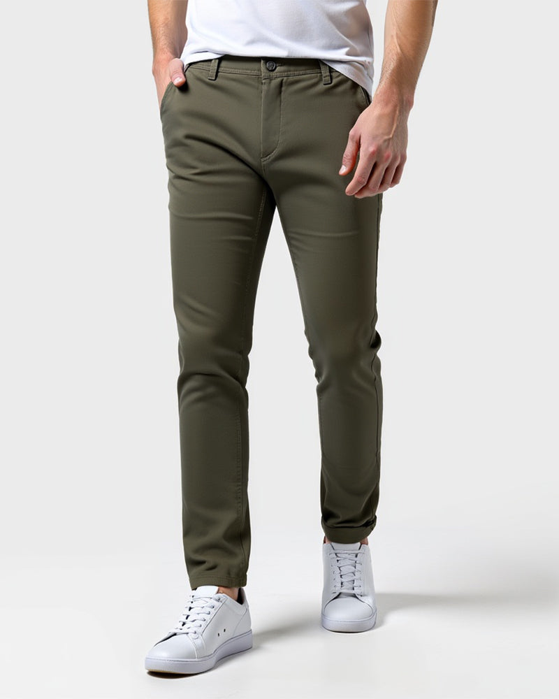 Oliven-grønne slim fit chinos set forfra på model med hvid t-shirt, hvide sneakers og hånden i lommen. 13