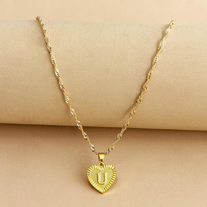 Goldene Herz-Halskette mit Buchstabenanhänger, gedrehtes Kettendesign, eleganter Schmuck.