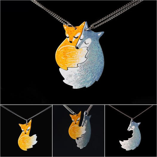Fuchs-Anhänger aus Metall, orange und silber, handgefertigt, auf schwarzem Hintergrund.