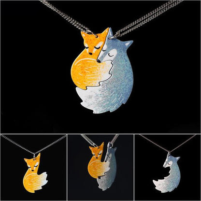 Fuchs-Anhänger aus Metall, orange und silber, handgefertigt, auf schwarzem Hintergrund.