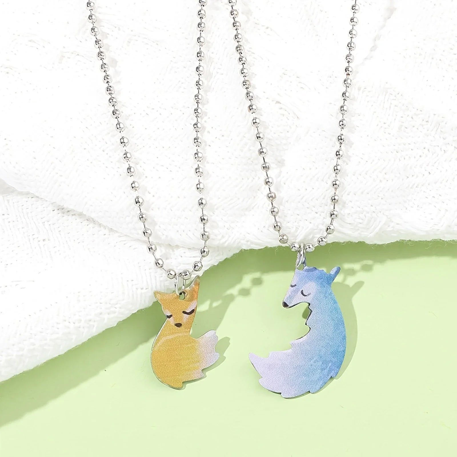 Zwei Fuchs-Halsketten, silberne Kette, gelber und blauer Anhänger, modischer Schmuck.