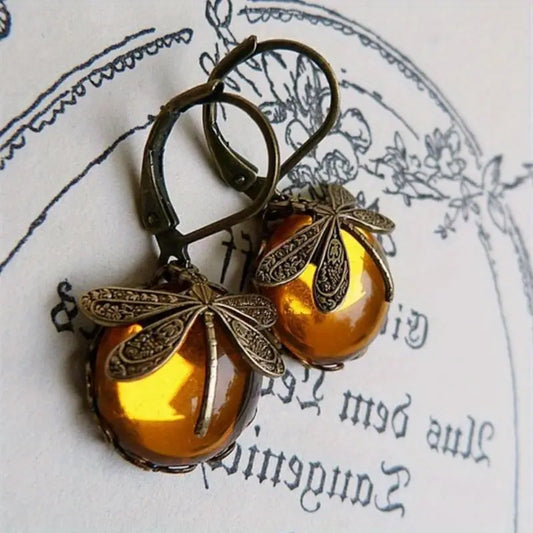 Antike Ohrringe mit gelben Steinen und Libellenmotiv, Vintage-Schmuck, Retro-Design.