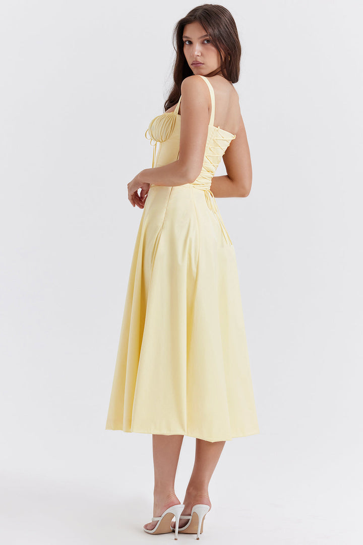 Frau in gelbem Sommerkleid mit Korsett-Detail, elegantes Design, Modefotografie.
