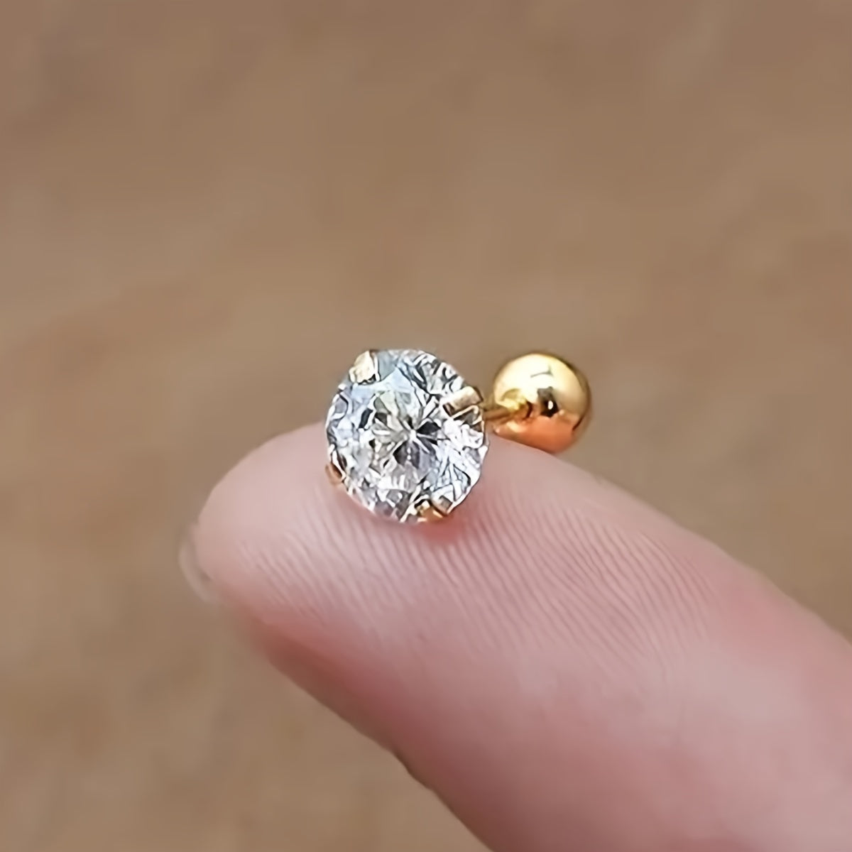 Goldener Nasenstecker mit rundem Diamant, funkelnd, eleganter Schmuck, Nahaufnahme.