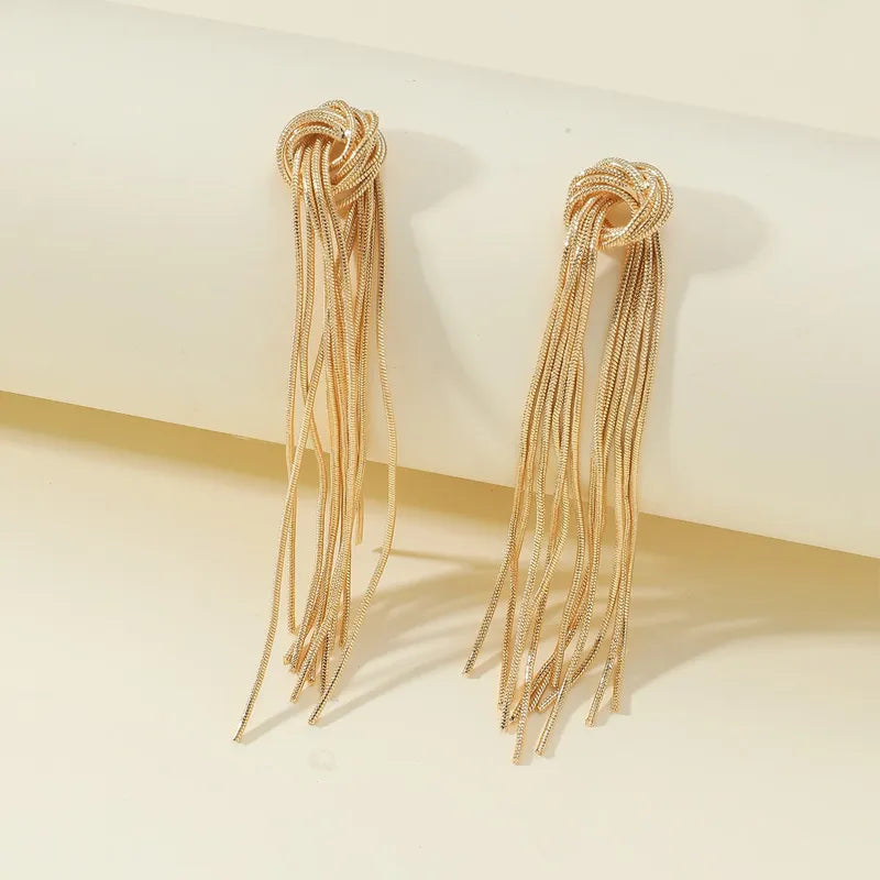 Goldene Knoten-Ohrringe mit langen Fransen, eleganter Schmuck für Damen, modisches Accessoire.