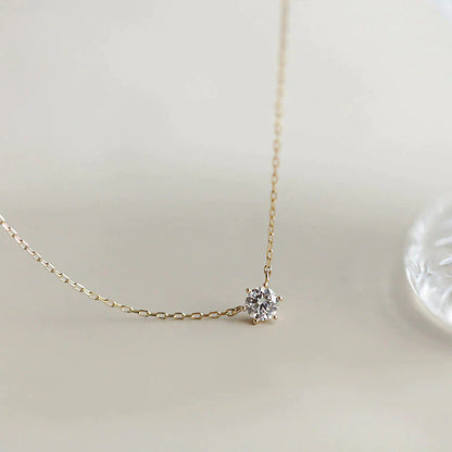 Goldene Halskette mit Diamantanhänger, eleganter Schmuck, minimalistisches Design.