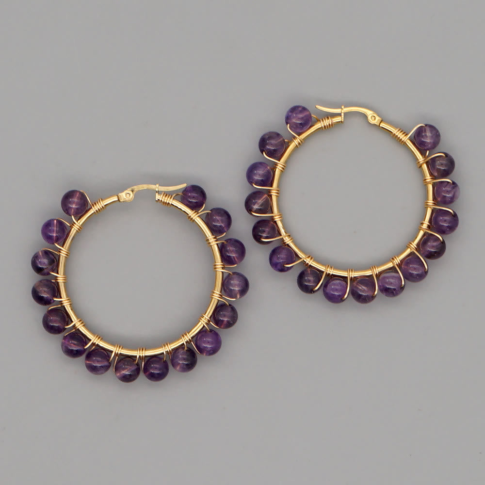 Goldene Creolen mit lila Amethyst-Perlen, handgefertigter Schmuck, elegantes Design.