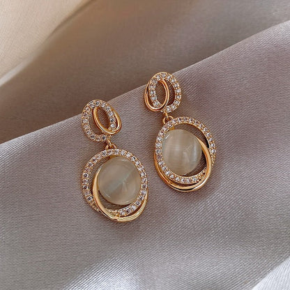 Goldene Ohrringe mit Strasssteinen, runde Form, elegantes Design, Damen-Schmuck.