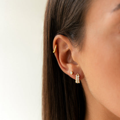 Frau mit goldenen Ohrringen und Perlen, eleganter Schmuck, Nahaufnahme, modisches Accessoire.
