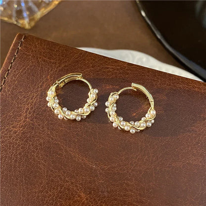 Goldene Creolen mit Perlen, eleganter Schmuck, modische Ohrringe, Damenaccessoire.