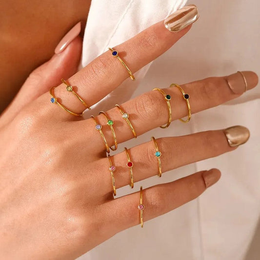 Frau mit goldenen Ringen, bunte Edelsteine, elegante Fingerringe, Schmuckmode, Handaccessoires.