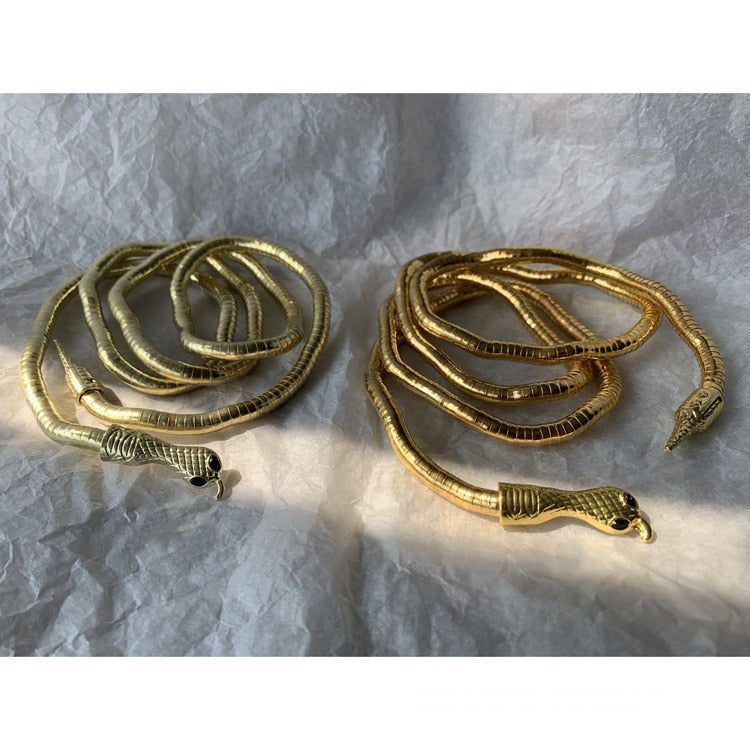 Zwei goldene Schlangenarmbänder, Metall, glänzend, Schmuck, modisch, Accessoire, Geschenkidee.