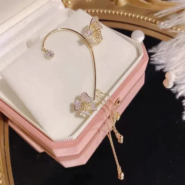 Goldene Schmetterlingsohrringe mit Strasssteinen auf rosa Schmuckschatulle.