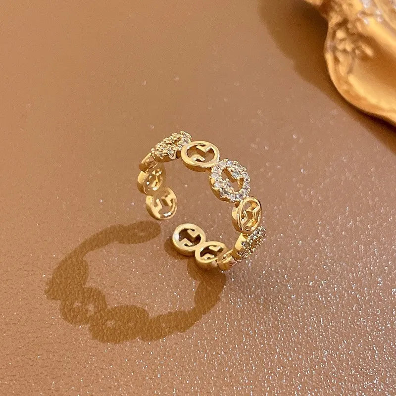 Goldener Ring mit Diamanten, Gucci-Logo, luxuriöses Schmuckdesign, elegantes Accessoire.