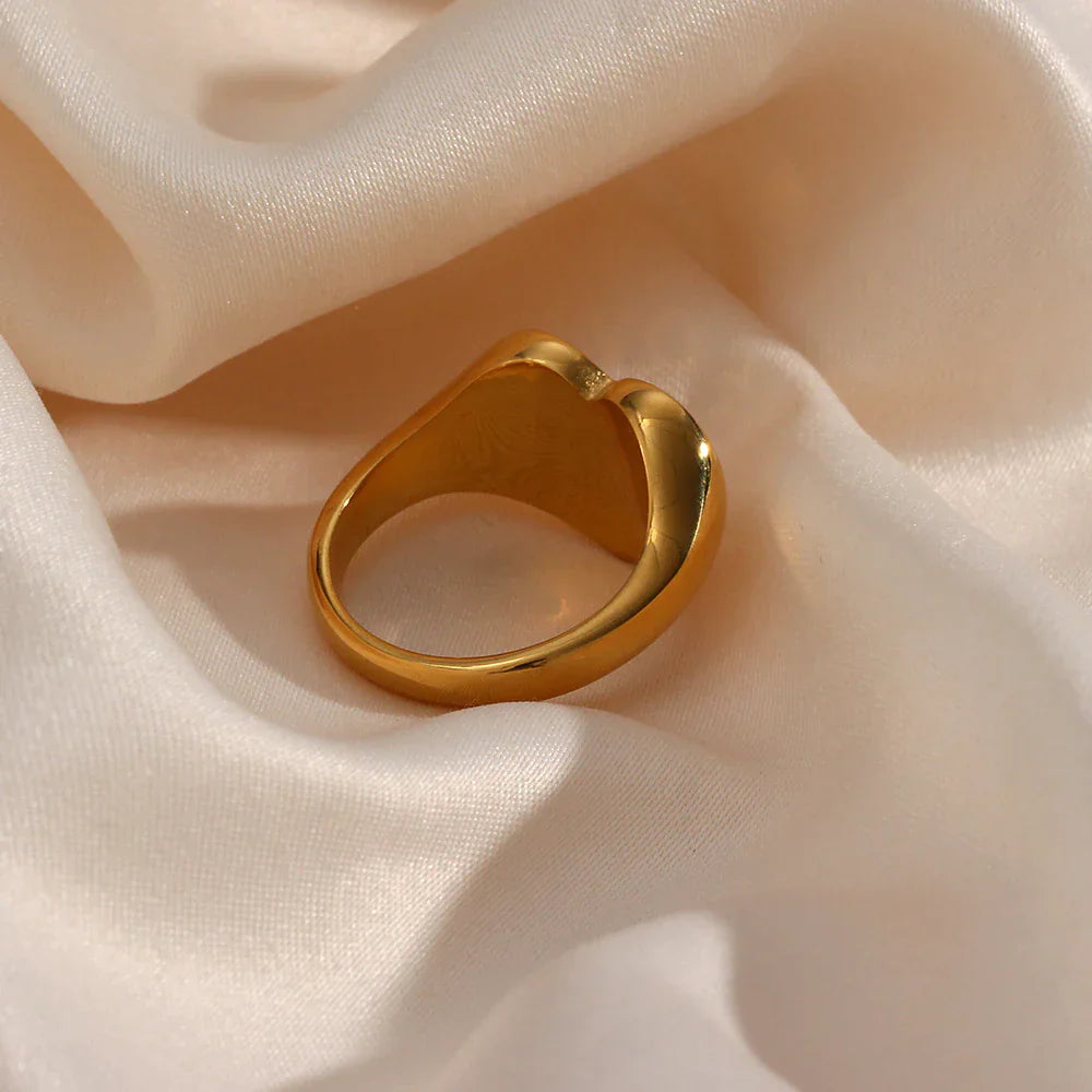 Goldener Ring auf beigem Satin, elegantes Schmuckdesign, glänzend, modisch, luxuriös.