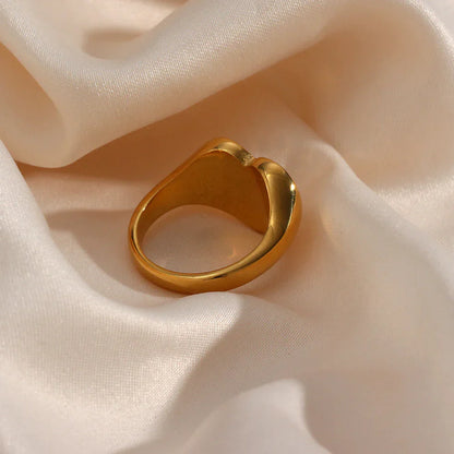 Goldener Ring auf beigem Satin, elegantes Schmuckdesign, glänzend, modisch, luxuriös.