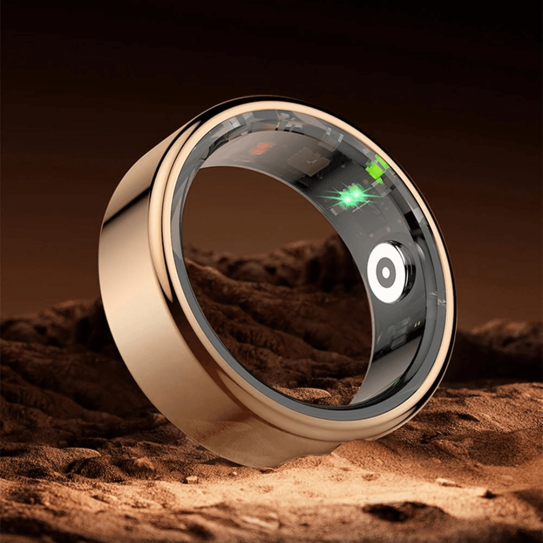Goldener Smart-Ring mit digitalem Display auf sandigem Untergrund, moderner Schmuck, Technologie.