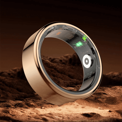 Goldener Smart-Ring mit digitalem Display auf sandigem Untergrund, moderner Schmuck, Technologie.