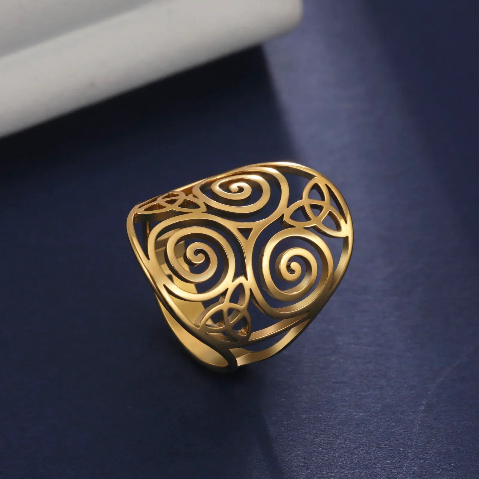 Goldener Ring mit filigranem Spiralmuster, eleganter Schmuck, modisches Accessoire.