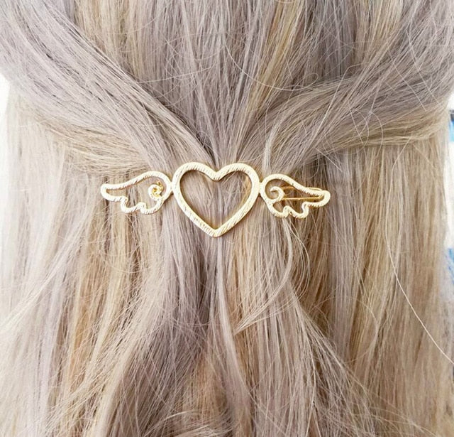 Goldene Herz-Haarspange mit Flügeln, elegantes Accessoire für Damenfrisuren.