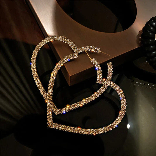 Goldene Herz-Ohrringe, funkelnde Strasssteine, modisches Schmuck-Accessoire, Damen-Mode.