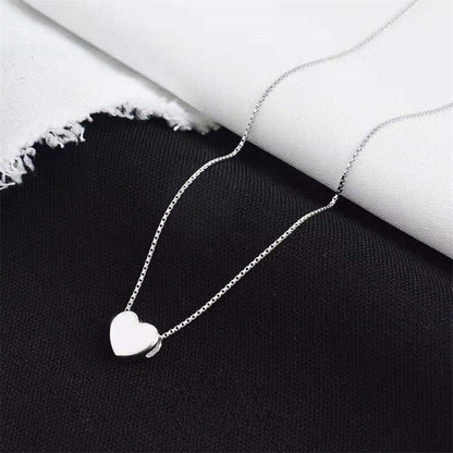 Silberne Herz-Halskette auf schwarzem und weißem Hintergrund, eleganter Schmuck für Damen.