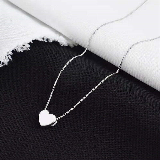 Silberne Herz-Halskette auf schwarzem und weißem Hintergrund, eleganter Schmuck für Damen.