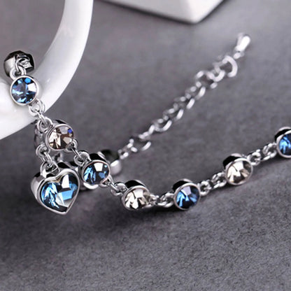 Silberarmband mit blauen und klaren Kristallen, Herzanhänger, eleganter Schmuck für Damen.