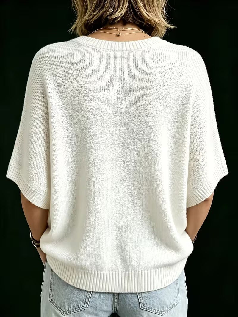 Cremehvid strikbluse set bagfra på model med lyse jeans, med ribkant ved hals, ærmer og linning. 25