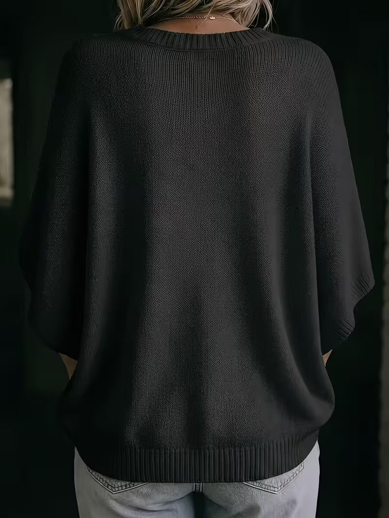 Sort strikbluse set bagfra på model med lyse jeans, med ribkant ved halsen og i bunden. 28