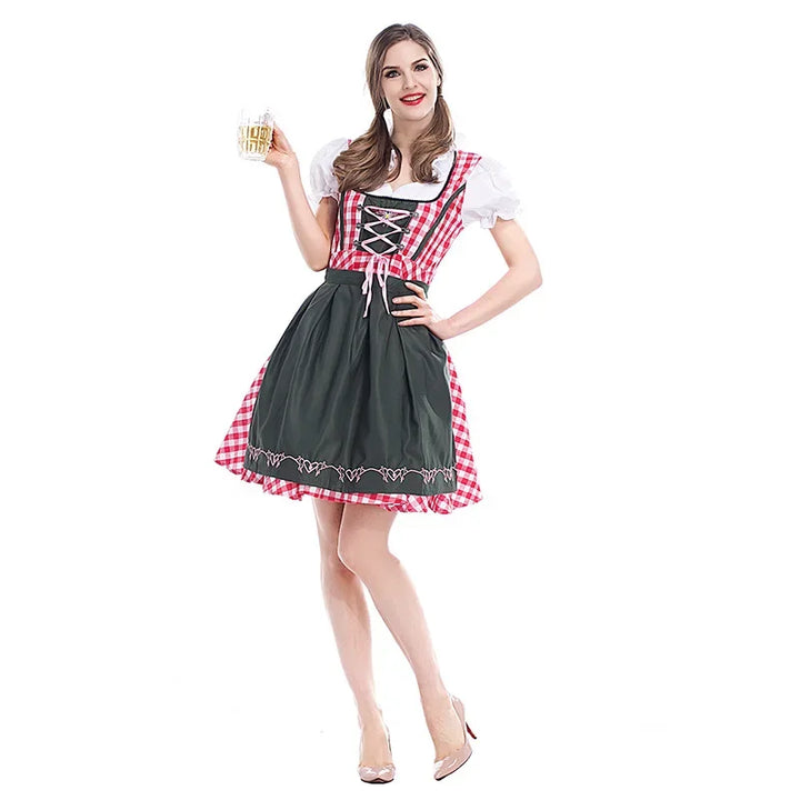 Model i rødternet dirndl med mørkegrøn forklæde og snøring foran, med et glas øl i hånden, set forfra. 1