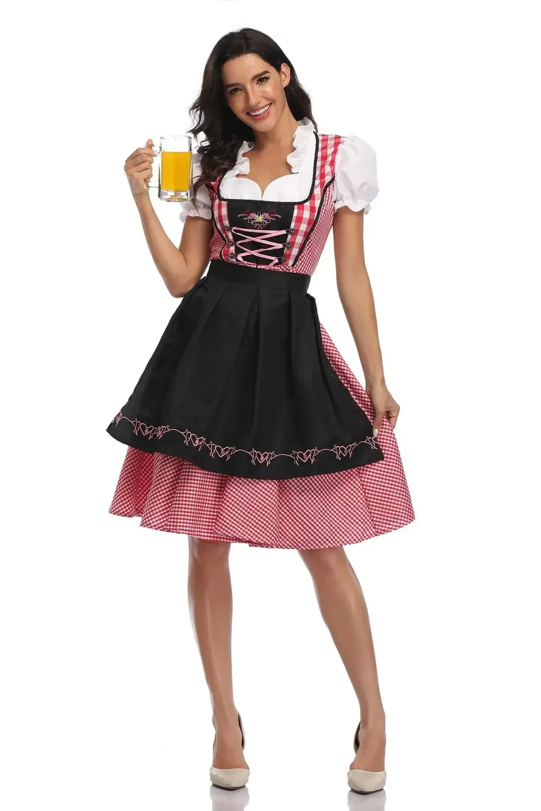 Model i rødternet dirndl med sort broderet forklæde og lyserød snøring, med et glas øl i hånden. 9