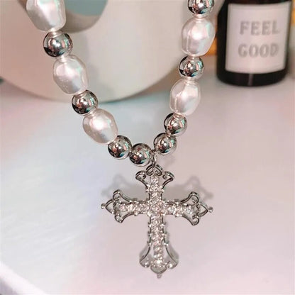 Silberne Kreuzkette mit Perlen und Metallkugeln, eleganter Schmuck für Damen.