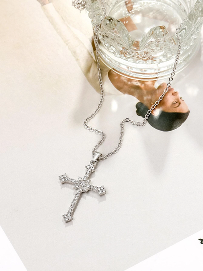 Silberne Kreuzkette mit Strasssteinen auf Glas und Foto, eleganter Schmuck für Damen.