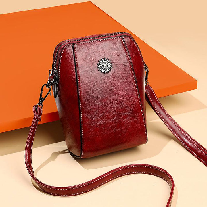 Mini læder crossbodytaske med blomsterdetalje - Liora