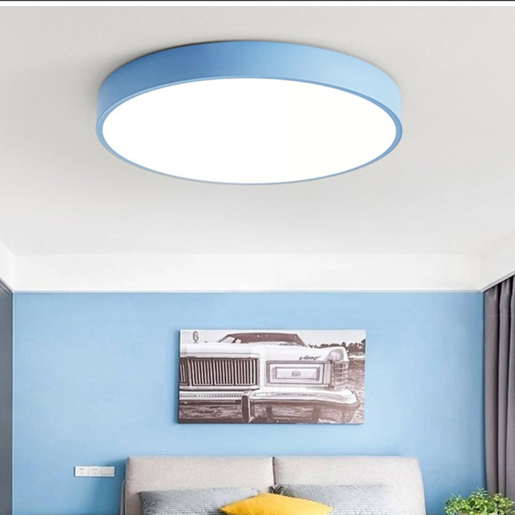 Lyseblå rund loftslampe uden trædetalje i loftet i et soveværelse med blå væg og billede af en bil. 4