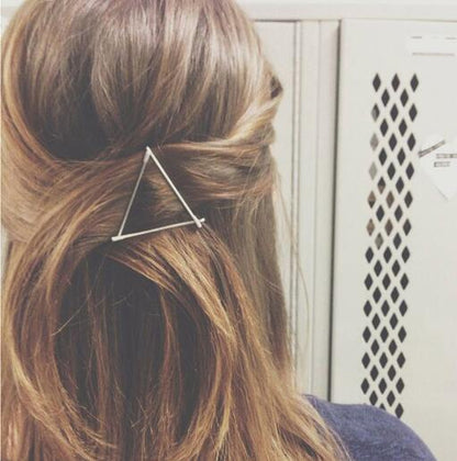 Frau mit braunem Haar und silberner dreieckiger Haarspange, modisches Accessoire.