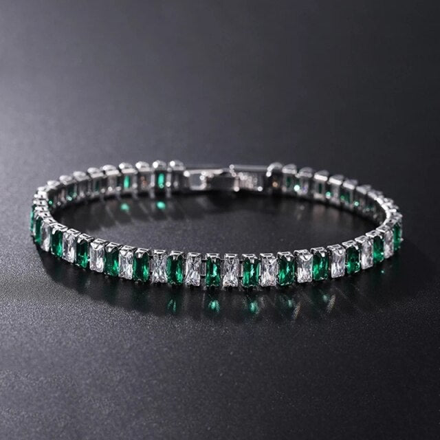 Silbernes Tennisarmband mit grünen und klaren Steinen, eleganter Schmuck für Damen.