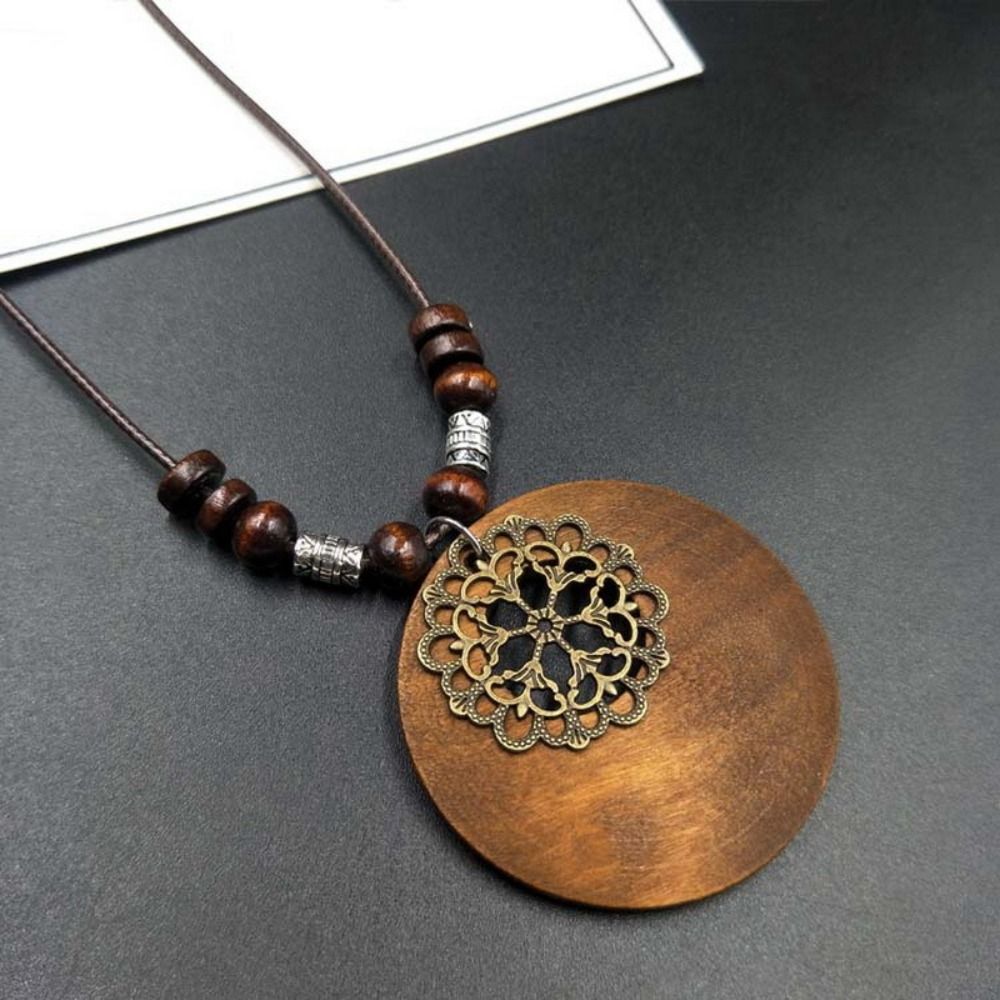 Holzanhänger Halskette, braun, mit filigranem Metallornament, Unisex-Schmuck, Boho-Stil.
