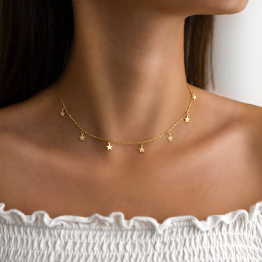 Goldene Sternen-Halskette auf weißem Hintergrund, eleganter Schmuck für Damen.